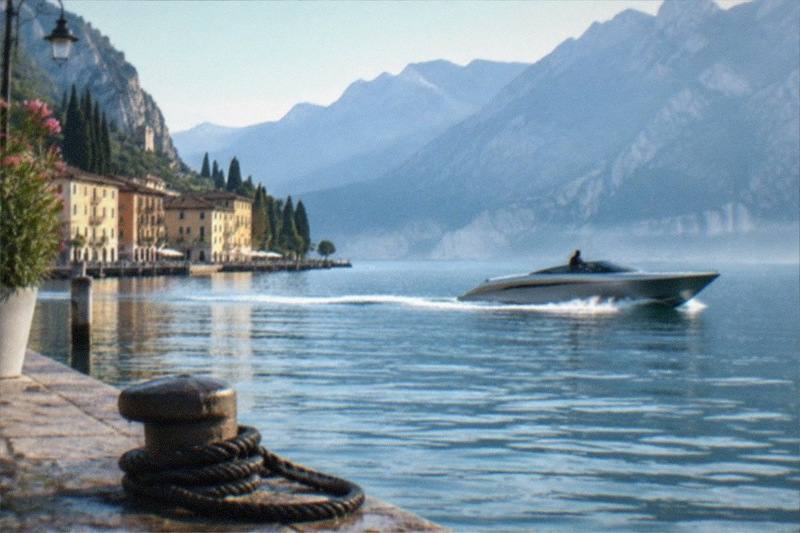 A sleek luxury speedboat carves through deep blue water near Riva del Garda, the skipper at the helm and the sheer rock faces of the northern lake towering above.