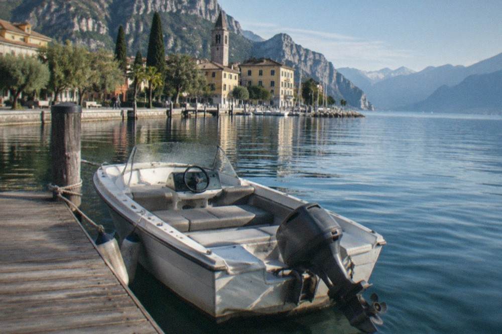An open rental motorboat moored at a wooden jetty on a clear morning