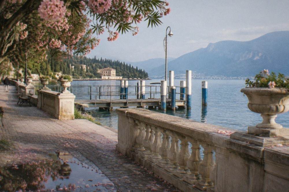 Spring lakeside promenade with blossom trees and calm blue water
