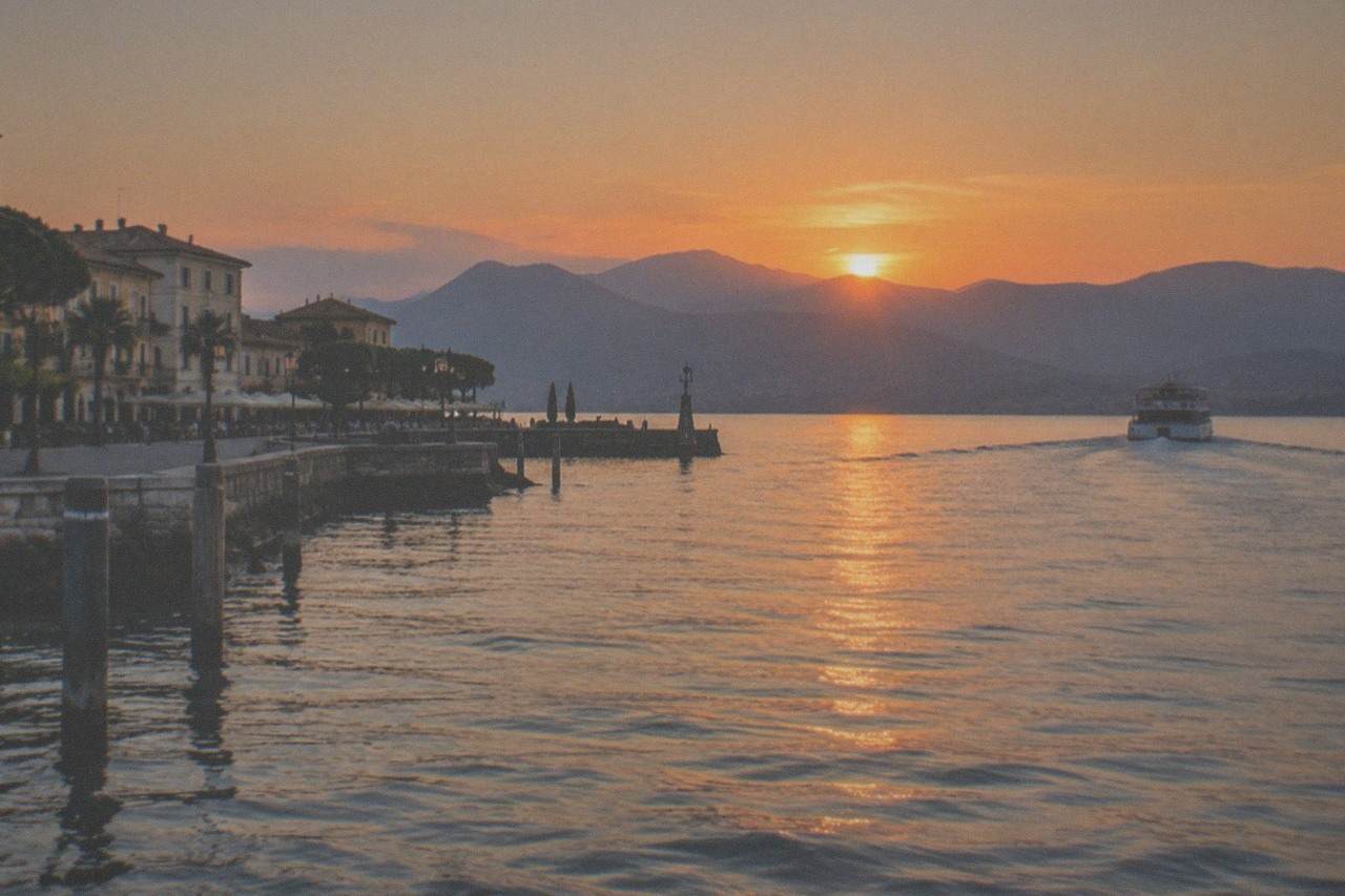 Sun setting over the western mountains of Lake Garda seen from the water