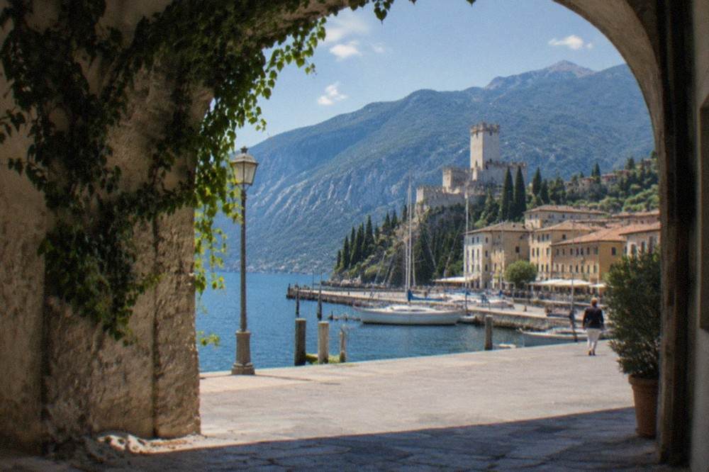 The Scaliger castle of Malcesine rising above the harbour with Monte Baldo in the background