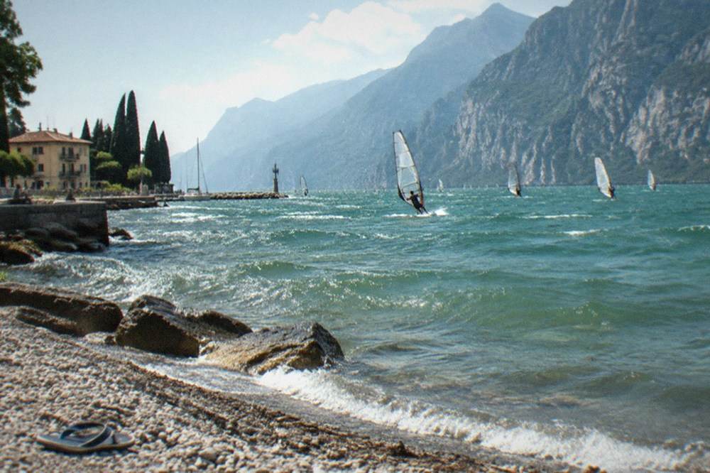 Windsurfers on Lake Garda near Riva del Garda with the mountains of the northern shore behind