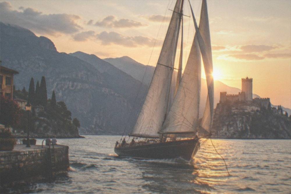 A historic sailboat on Lake Garda near Malcesine with the castle in the distance