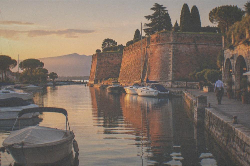 The Peschiera fortress walls and moored boats at golden hour on southern Lake Garda