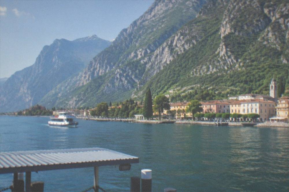 Steep mountains rising directly from blue water with a small town at the shoreline