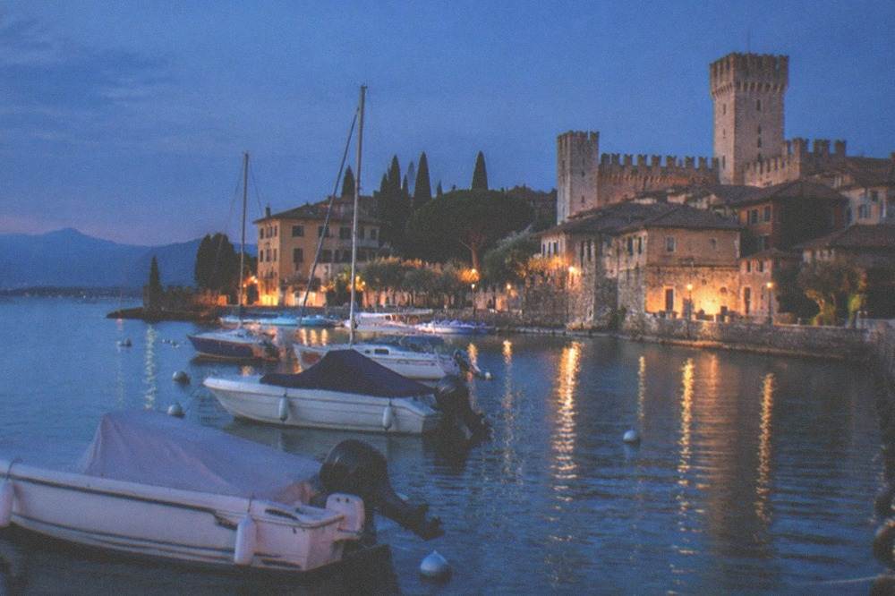 Evening light over Sirmione harbour with boats at their moorings