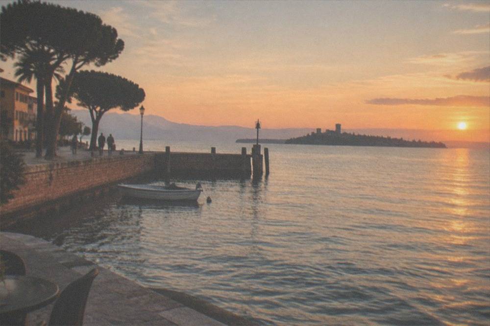 Low golden sunset light over Lake Garda with a distant peninsula silhouette