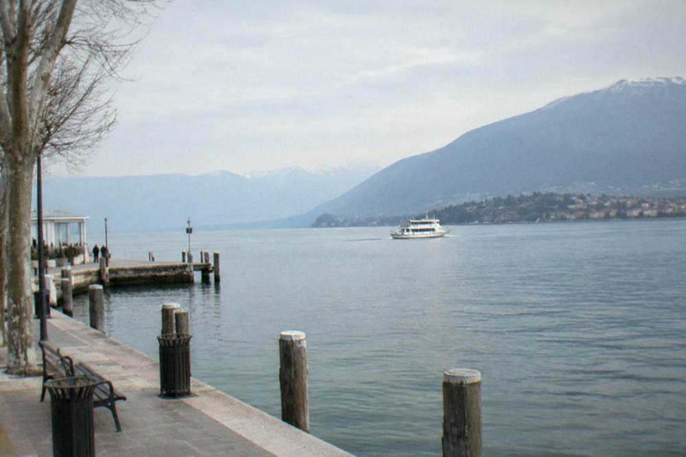 A passenger ferry crossing the wide southern basin of Lake Garda under a pale winter sky