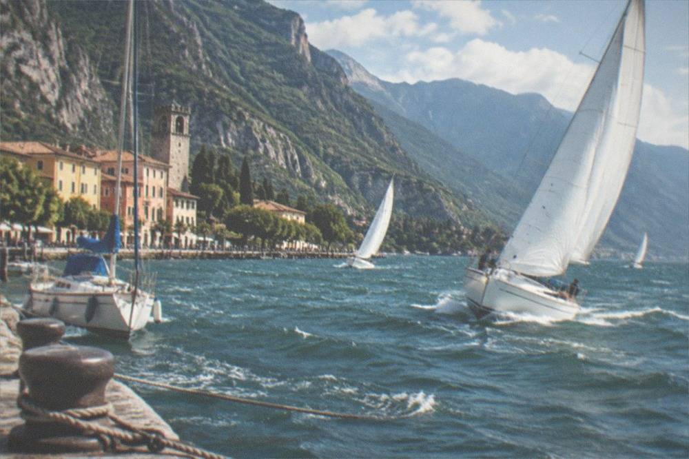 Sailboats heeling in a fresh afternoon breeze on the northern part of Lake Garda