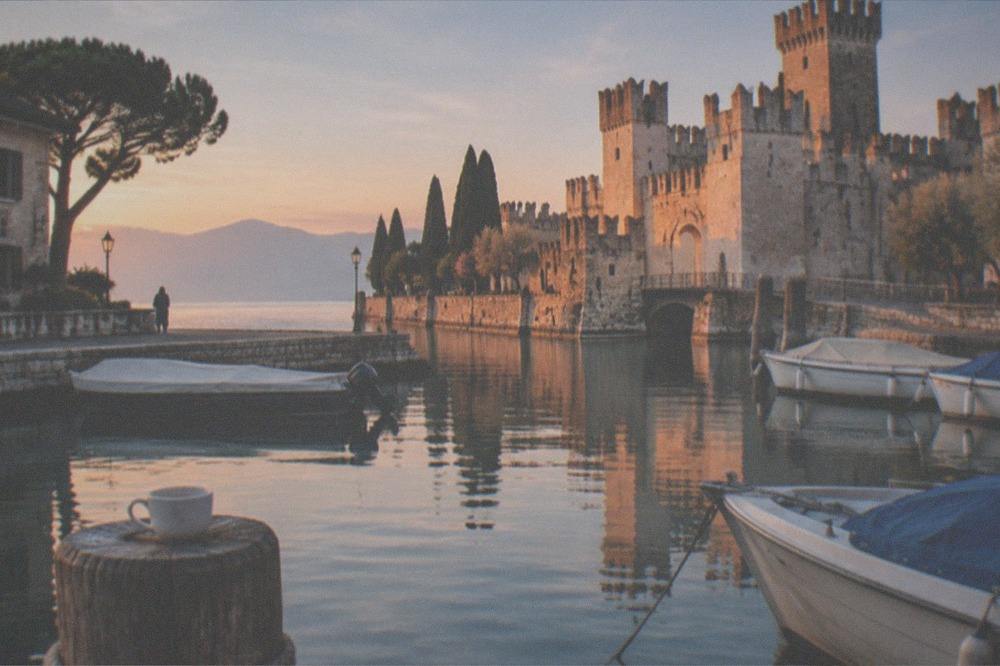Small tour boats moored at the harbour inside the old town of Sirmione