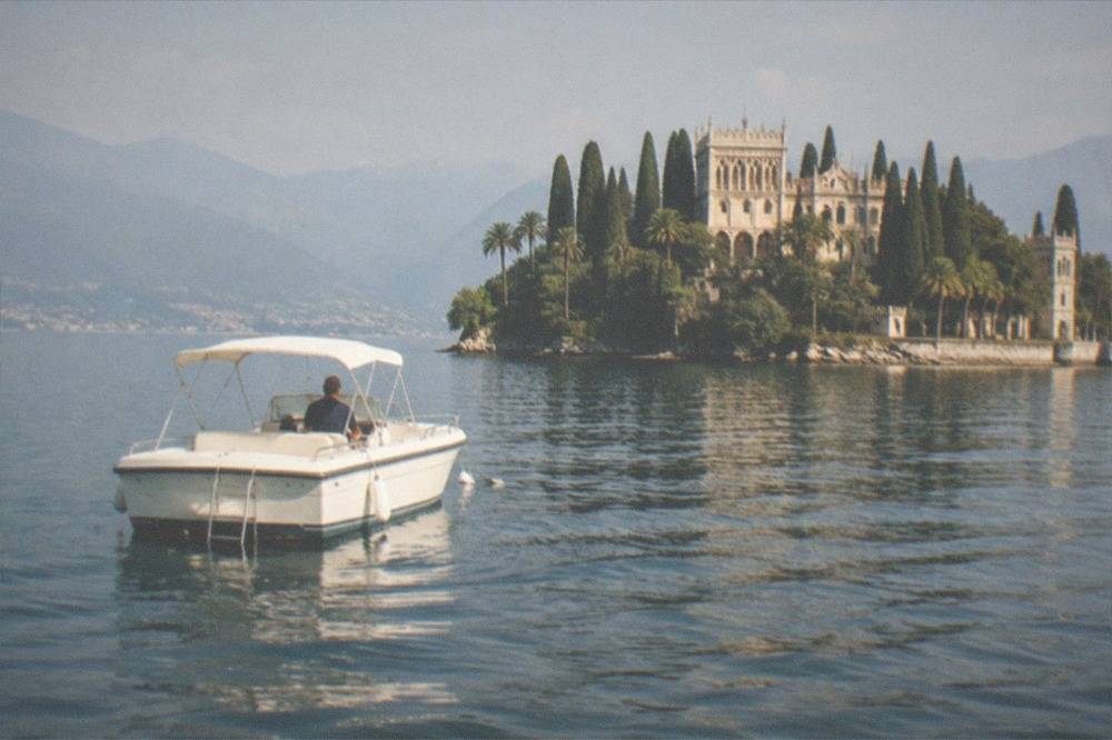 A small boat anchored in clear deep water away from the Lake Garda shore
